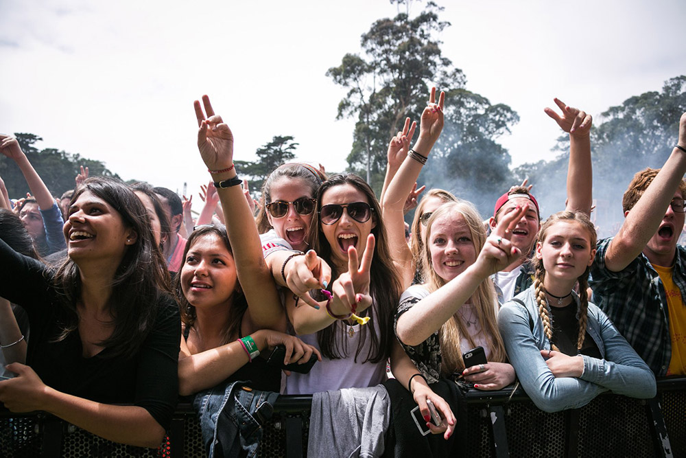 Image of young women at the front of a festival stage excited